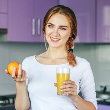 young-woman-drinking-orange-juice-in-the-kitchen-2022-02-07-21-28-39-utc-min